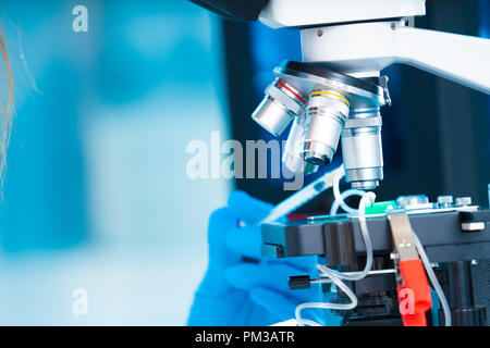 Techniker Mädchen mit mikrofluidischen Gerät LOC im mikrobiologischen Labor Stockfoto