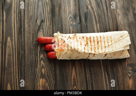 Hausgemachte Wurst in pita Brot auf hölzernen Hintergrund. Foto mit Stockfoto