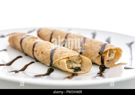 Seitenansicht des hausgemachten Pfannkuchen auf einen Teller mit Schokolade verziert. Stockfoto