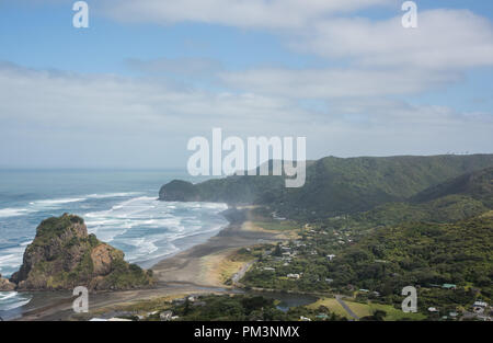 Erhöhten Blick auf die vulkanischen schwarzen Sand Piha Beach mit dem Tasmanischen Meer Wellen und große Lion Rock Sehenswürdigkeiten in Auckland, Neuseeland Stockfoto