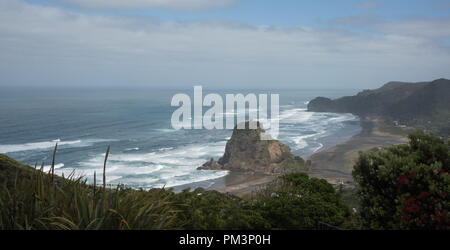 Erhöhten Blick auf die vulkanischen schwarzen Sand Piha Beach mit dem Tasmanischen Meer Wellen und große Lion Rock Sehenswürdigkeiten in Auckland, Neuseeland Stockfoto