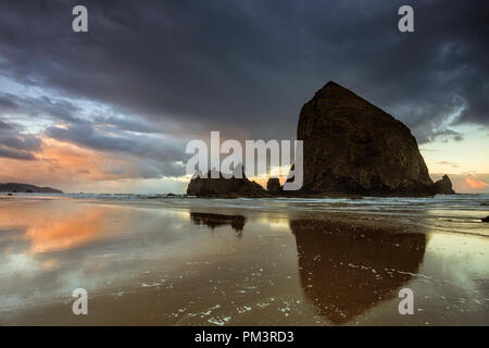 Des Oregon Haystack Rock entlang Cannon Beach am Abend Stockfoto