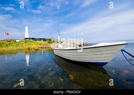 Angeln Boot festgemacht an der Küste der Ostsee in Allinge, Bornholm, Dänemark. Schornstein der Räucherei im Hintergrund. Stockfoto