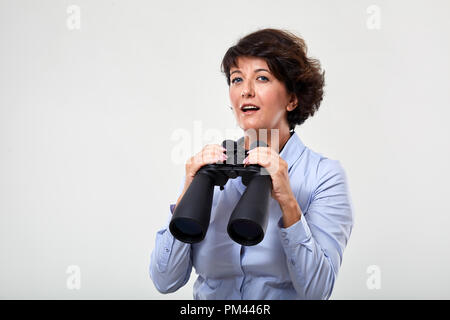 Konzeptionelle Schuß eines reifen Geschäftsfrau mit großen Fernglas Stockfoto