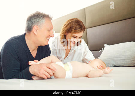 Großeltern und das Baby Spielen auf dem Bett. Stockfoto