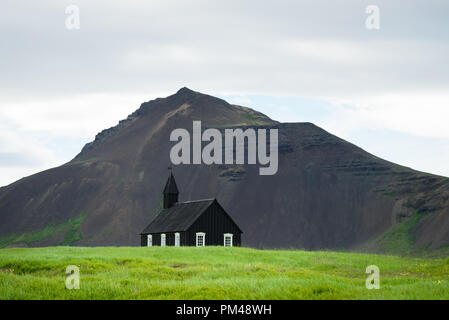 Budir Kirche in Island. Schwarze Kapelle auf dem Hintergrund der Berge. Sommer Landschaft. Religiöse und touristische Attraktion Stockfoto