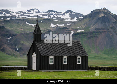 Budakirkja - Schwarze Kirche. Religiöse und touristische Attraktion von Island. Sommer Landschaft mit einer Kapelle und die Berge Stockfoto