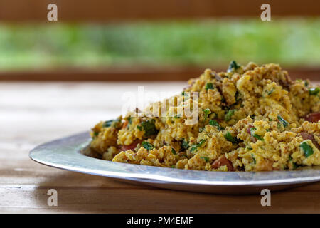 Rührei oder Omelett aus Eiern, Würstchen, Zwiebeln, frischen Kräutern Stockfoto
