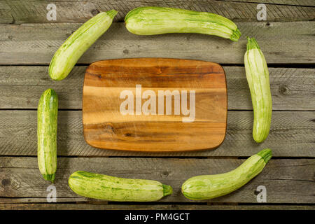 Hellgrün frische Zucchini gestapelt, Bauernhof mit den frischen Produkten, den Sommer Gemüse auf rustikalen Hintergrund. Ansicht von oben Stockfoto