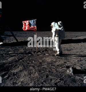 Astronaut Buzz Aldrin, Lunar Module pilot Der erste Mondlandung Mission, posiert für ein Foto neben dem Einsatz United Flaggenstaaten während einer Apollo 11 Extra Vehicular Activity (EVA) auf der Mondoberfläche. Die Landefähre (LM) ist auf der linken Seite und die fußspuren der Astronauten sind deutlich im Boden des Mondes sichtbar. A. in der Astronaut Neil Armstrong, Kommandant, nahm dieses Bild mit einem 70 mm Hasselblad Mondoberfläche Kamera, 20. Juli 1969. Datei Referenz Nr. 1001 012 THA