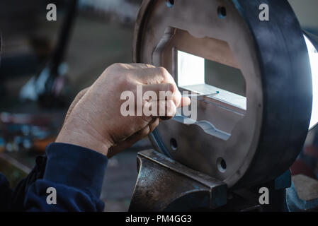 Der Handwerker Glättung der Metallform Stockfoto