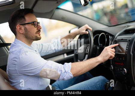 Mann mit GPS-Navigationssystem im Auto. Stockfoto