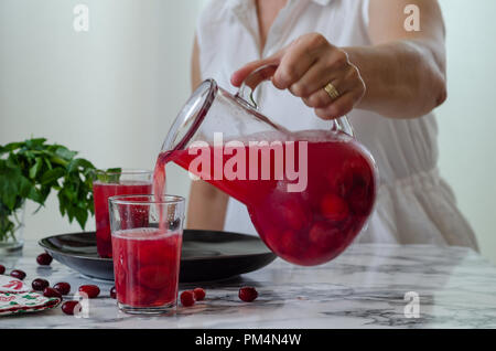 Frau füllt Cranberry Saft im Glas. Es ist gesund, hausgemachte trinken. Stockfoto