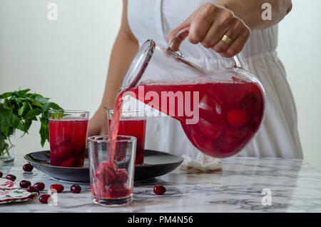 Frau füllt Cranberry Saft im Glas. Es ist gesund, hausgemachte trinken. Stockfoto
