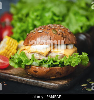 Huhn Cheeseburger mit grünem Salat und Soße. Detailansicht. Leckere Cheeseburger Stockfoto