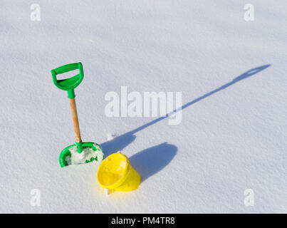 Schaufel und Eimer im tiefen Schnee einen langen Schatten Vorlage Geschenkgutschein Stockfoto