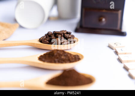 Holzlöffel mit Kaffee Bohne und gemahlen gemahlener Kaffee auf weißem Hintergrund Stockfoto