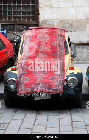 Ägypten, Kairo 2014. Khan al-Khalilli, alten islamischen Bereich. Alten Teppich auf Volkswagon beetle Auto. Stockfoto