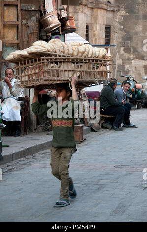 Ägypten, Kairo 2014. Khan al-Khalilli, alten islamischen Bereich. Junge Junge, die ein sehr großes Fach der traditionellen pita Art Brot. Stockfoto