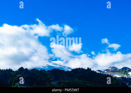 Blauer Himmel und weiße geschwollene Wolken über einem Berg landscale Stockfoto