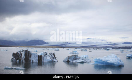 Eisberge Abdriften in der Gletscherlagune Jökulsárlón aus der Kalbenden Gesicht von Breiðamerkurjökull an einem trüben Tag. Stockfoto