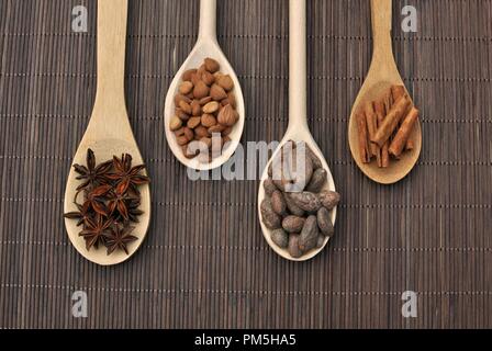 Konzept mit Zutaten für Schokolade, Kakao, Zimt, Anis, Aprikose Bohnen auf holzlöffel auf braunem Hintergrund, Ansicht von oben Stockfoto