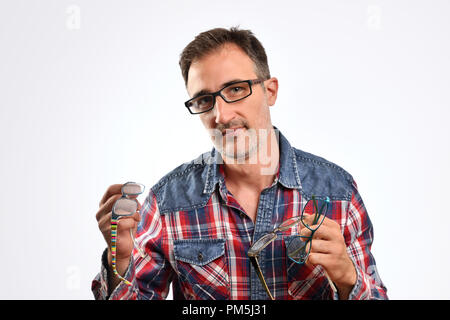 Mann mit mehreren Gläsern in der Hand auf der Suche nach vorne. Konzept der optische Korrektur mit Brille. Horizontale Zusammensetzung Stockfoto