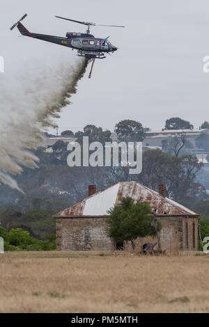 Feuerwehr Hubschrauber fallen Wasser auf einem buschfeuer nördlich von Perth droht eine historische Farm Stockfoto