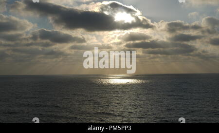 Eine Landschaft Meerblick zeigt die Sonne durch die Wolken bis zum Meer Oberfläche schaffen eine besondere Breite licht Tropfen auf die Wasseroberfläche Stockfoto