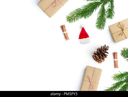 Frohe Weihnachten layout Zusammensetzung, Ansicht von oben mit Geschenke, Zimtstangen, Tannenbaum, Zweige und Tannenzapfen auf einem weißen Hintergrund. Stockfoto