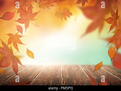 Herbst Kulisse mit fallenden Baum Blätter und ein Holztisch. Stockfoto