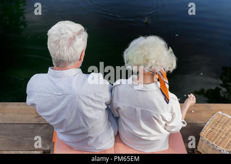 Blick von oben auf die älteren Leute sitzen auf der Brücke zusammen Stockfoto