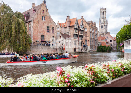 Brügge, Belgien - 27. August 2018: Boot voller Touristen im Wasser Kanal der malerischen Altstadt von Brügge in die flämische Region von Belgien Stockfoto