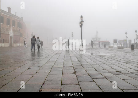 Venedig, Italien, 12. Januar - 2018 - Winter neblig städtische Szene mit Menschen zu Fuß an der Straße in der Stadt Venedig, Italien Stockfoto