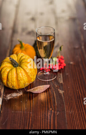 Stilleben mit Wein, Kürbisse und Herbstlaub auf hölzernen Hintergrund Stockfoto