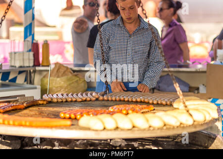 CERVIA (RA), Italien - 16. SEPTEMBER 2018: Mann kochen Würstchen und Brot auf Grill wie die bayerische Küche im europäischen Markt, Straße Ausstellung o Stockfoto