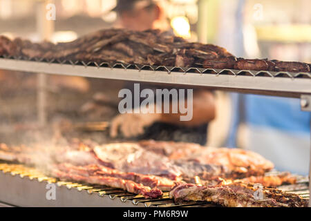 Argentinische Fleisch ist das Rauchen beim Backen auf dem Grill in ein Markt Stockfoto