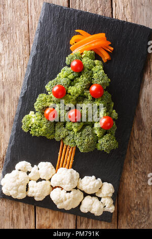 Weihnachtsbaum von Brokkoli, Blumenkohl, Tomaten, Pfeffer closeup auf Tisch. Vegetarisches Menü. Senkrechte Draufsicht von oben Stockfoto