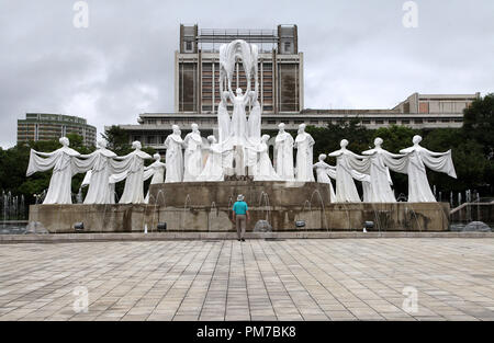 Touristen bewundern die Skulptur als Schnee fällt bei mansudae Brunnen Park in Pjöngjang Stockfoto