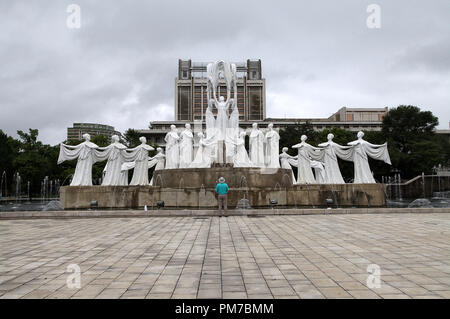 Touristen bewundern die Skulptur als Schnee fällt bei mansudae Brunnen Park in Pjöngjang Stockfoto