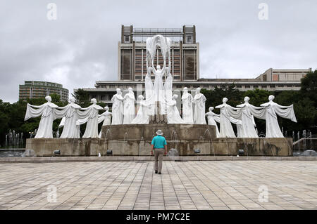 Touristen bewundern die Skulptur als Schnee fällt bei mansudae Brunnen Park in Pjöngjang Stockfoto