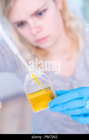 Nahaufnahme von jungen weiblichen Wissenschaftler im Genetik Labor mit Pipette in Weiß biologische Probe Stockfoto