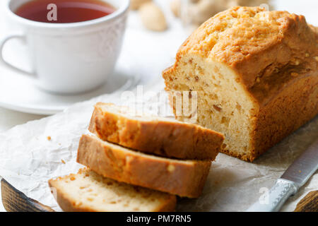 In Scheiben geschnitten pound Kuchen mit Mandeln auf dem Schneidebrett. Hausgemachte Kuchen mit Nüssen und Honig. Delikatesse Snack für Tee. Selektiver Fokus Stockfoto