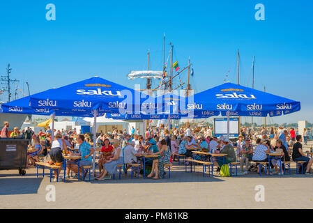 People Cafe Sommer, Blick an einem Sommernachmittag des Sonntags Besucher des Lennusadam Wasserflugzeug Hafen Essen Mittagessen unter Sonnenschirmen, Tallinn, Estland. Stockfoto