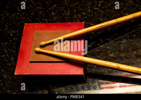 Drum Sticks auf Practice Pad mit amerikanischer Flagge teilweise in ubatuba Granit reflektierte rest Snare. Stockfoto