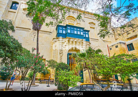 VALLETTA, MALTA - 17. JUNI 2018: Entspannen Sie sich im Garten von Prince Alfred in den Hof des Grandmaster Palast, das kleine schattige Fläche mit üppigen Bäumen und Sitzbank Stockfoto