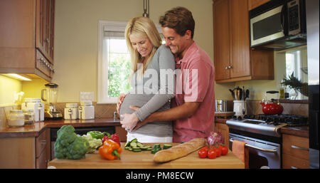 Glücklich schwanger Paar in der Küche Stockfoto
