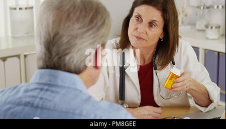 Ältere Patienten sprechen Arzt über Verschreibung im Büro Stockfoto