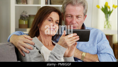 Glücklich verheiratetes Paar mit Smartphone Stockfoto