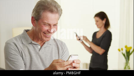Fröhlicher älterer Mann mit Smartphone Stockfoto